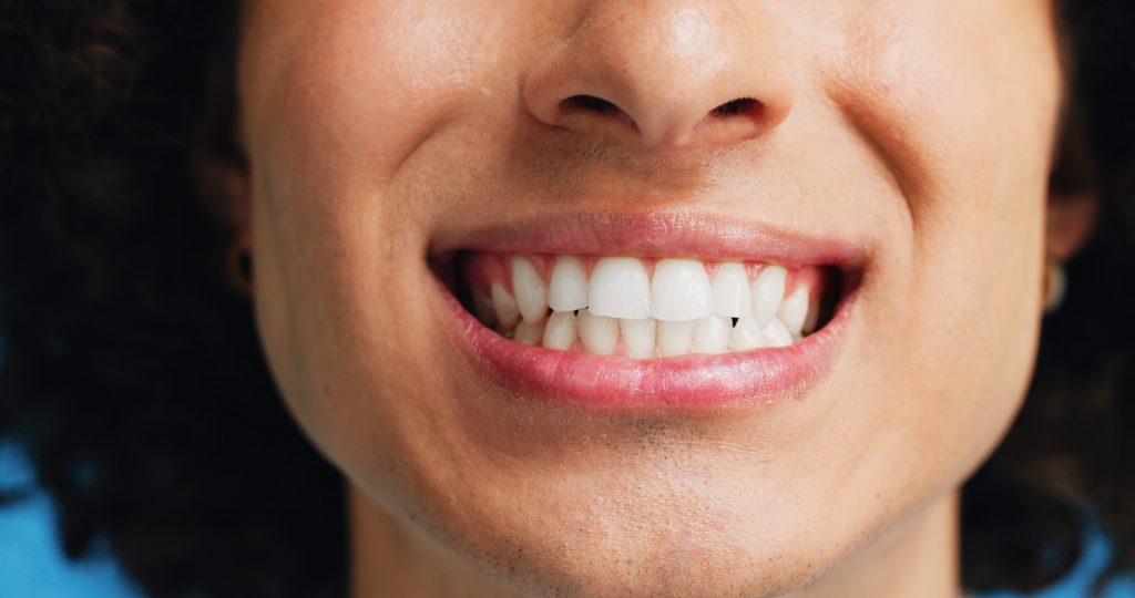 Persona sonriente con encías fuertes y perfectas.